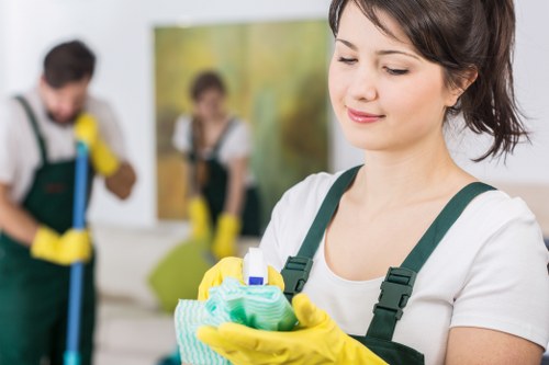 Staff member wearing PPE while cleaning an oven interior